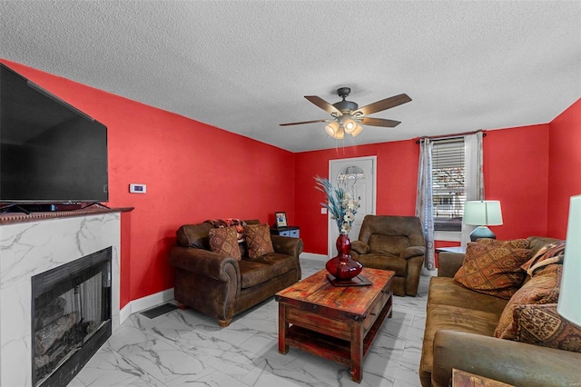 living room with marble finish floor, ceiling fan, baseboards, and a premium fireplace