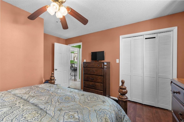 bedroom featuring ceiling fan, dark wood-style floors, a closet, and a textured ceiling