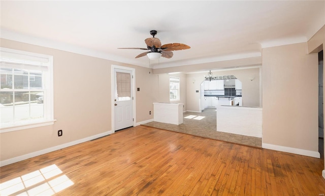 unfurnished living room featuring baseboards, light wood-style floors, and a ceiling fan