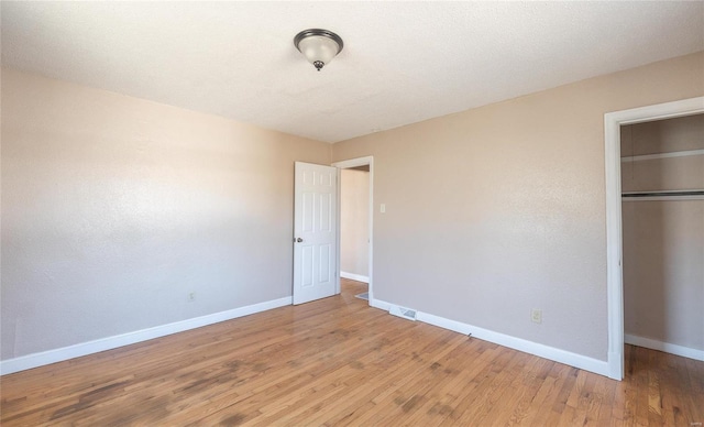 unfurnished bedroom with visible vents, baseboards, a closet, and light wood finished floors