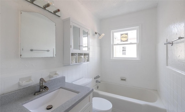 full bathroom featuring shower / bathing tub combination, toilet, tile walls, and vanity