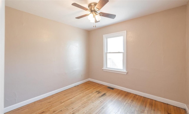 spare room with ceiling fan, visible vents, baseboards, and light wood-style flooring