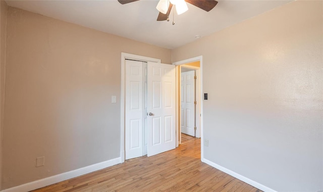 unfurnished bedroom with a ceiling fan, light wood-style floors, baseboards, and a closet