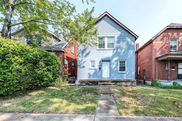 view of front of home with brick siding and a front lawn