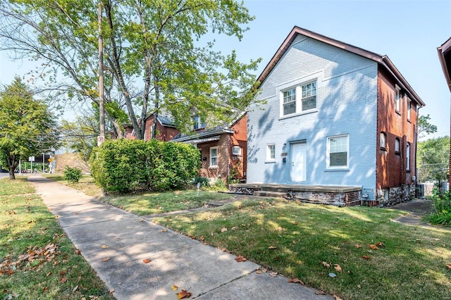 view of front of home with a front yard and brick siding