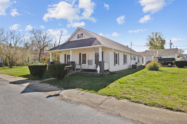 view of front of home with a front yard, covered porch, and a shingled roof