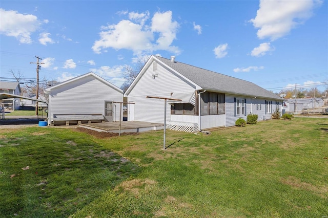 rear view of house featuring a yard and a sunroom