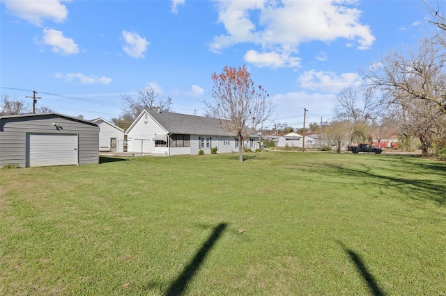 view of yard featuring an outbuilding, driveway, and a detached garage