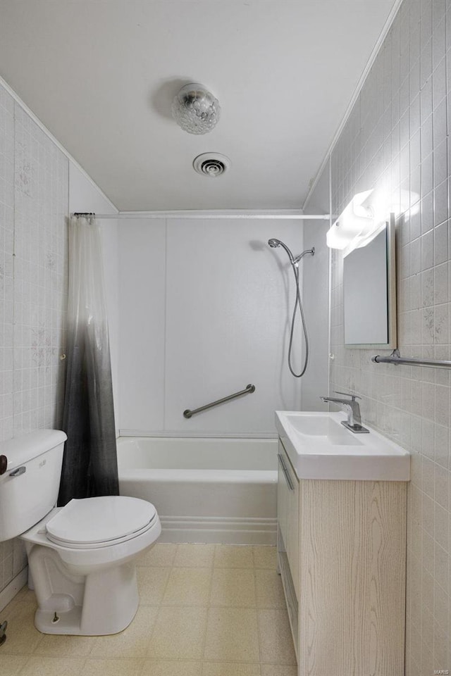 bathroom with tile patterned floors, visible vents, toilet, tile walls, and shower / bath combination