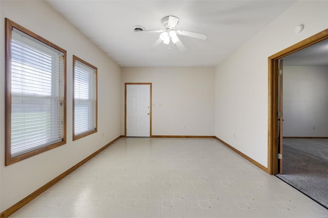 unfurnished room with baseboards, light floors, and a ceiling fan