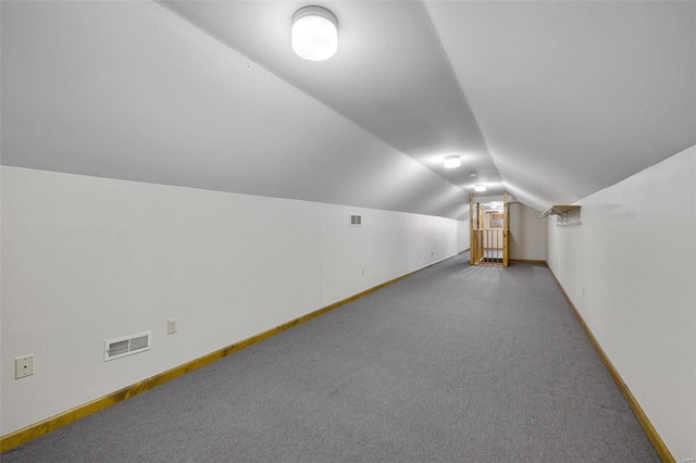 additional living space with visible vents, baseboards, and vaulted ceiling