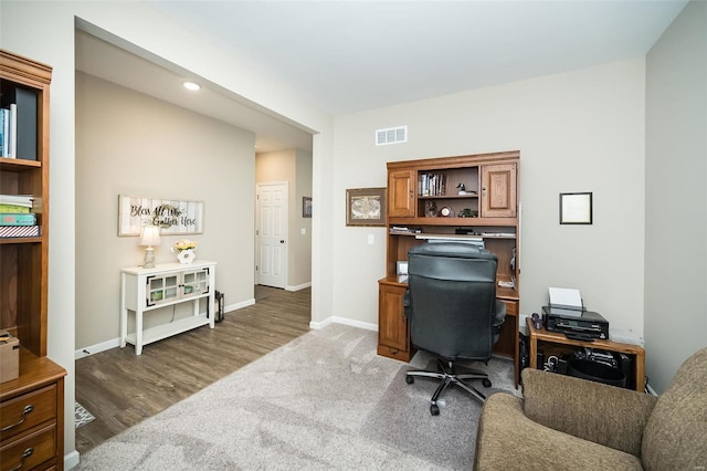 home office with carpet, wood finished floors, baseboards, and visible vents