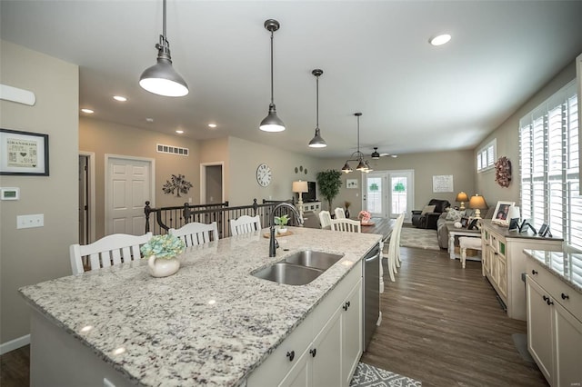 kitchen with visible vents, dark wood finished floors, dishwasher, french doors, and a sink