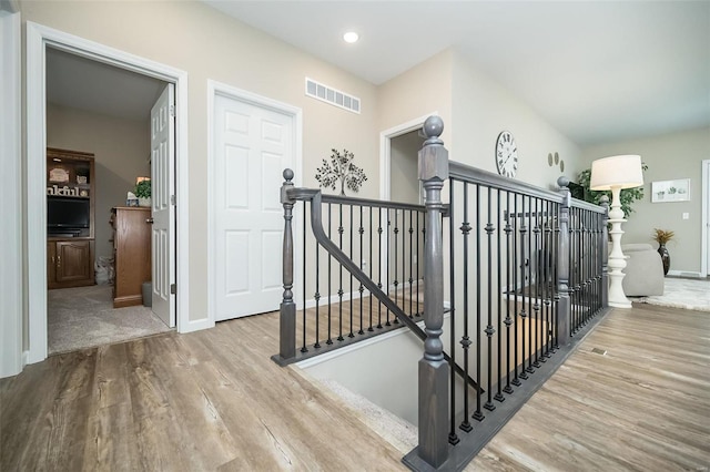 stairs with recessed lighting, visible vents, baseboards, and wood finished floors