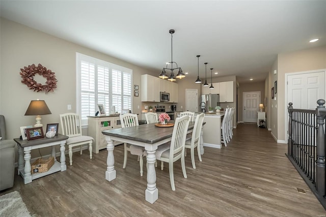 dining room with recessed lighting, a chandelier, baseboards, and wood finished floors