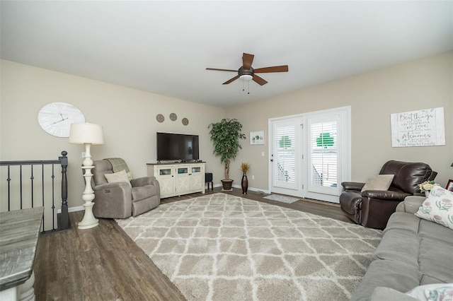 living area featuring a ceiling fan, baseboards, and wood finished floors