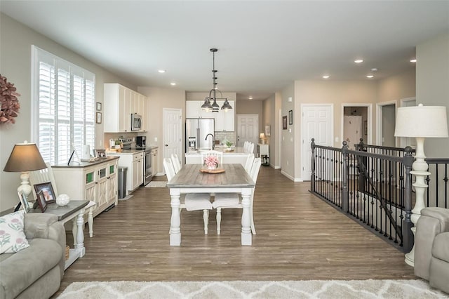 dining room with recessed lighting, baseboards, an inviting chandelier, and dark wood-style flooring