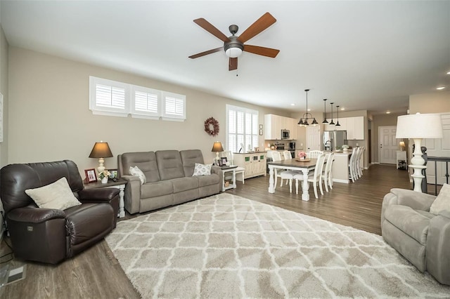 living area featuring recessed lighting, dark wood-type flooring, and a ceiling fan