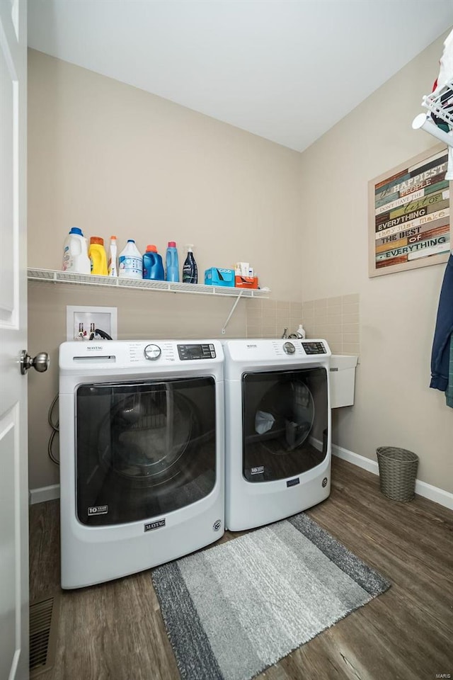 laundry area featuring laundry area, washing machine and dryer, baseboards, and wood finished floors