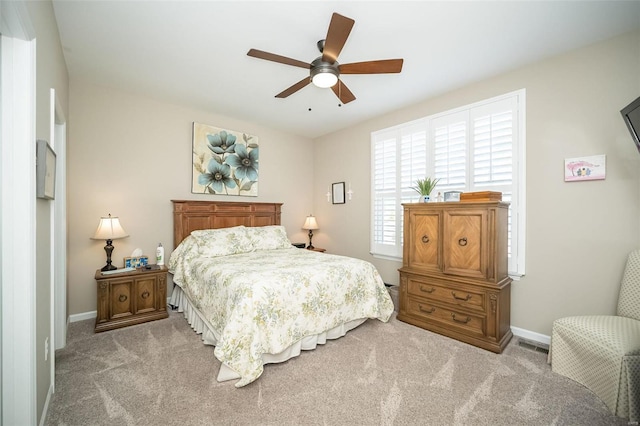 carpeted bedroom with a ceiling fan, baseboards, and visible vents