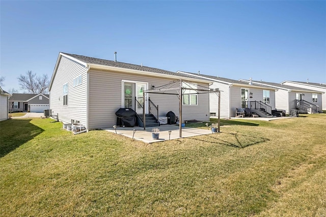 rear view of house with a patio, central air condition unit, and a yard