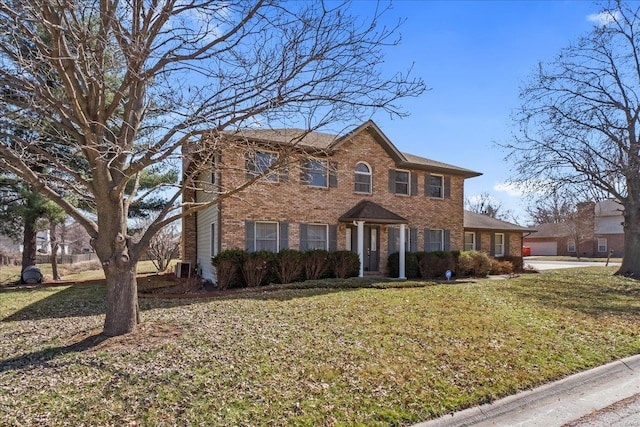 colonial home with brick siding and a front yard