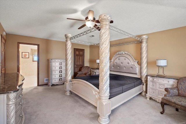 bedroom with visible vents, ceiling fan, ensuite bathroom, a textured ceiling, and light carpet