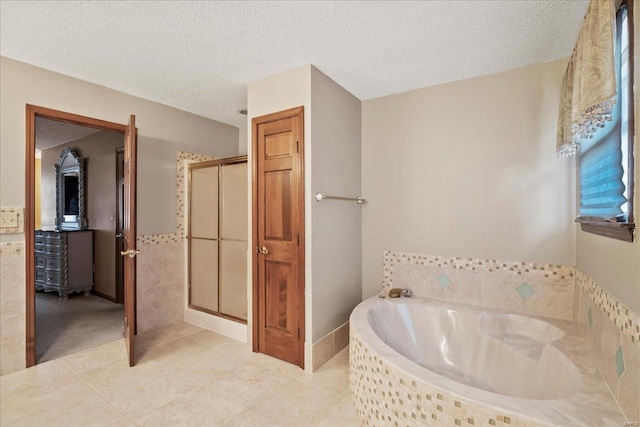 bathroom featuring a shower stall, a garden tub, tile patterned floors, and a textured ceiling