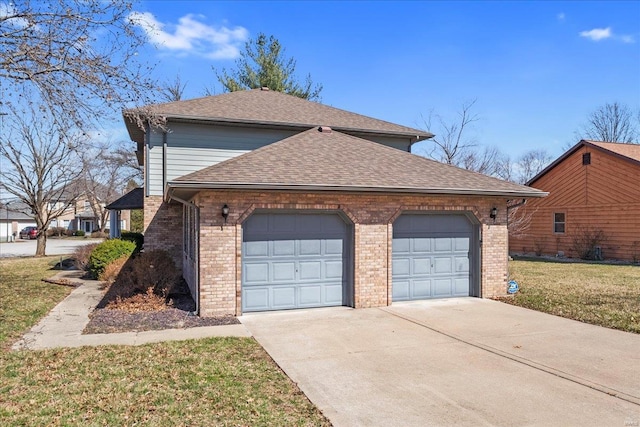 view of side of property with a yard, roof with shingles, concrete driveway, a garage, and brick siding