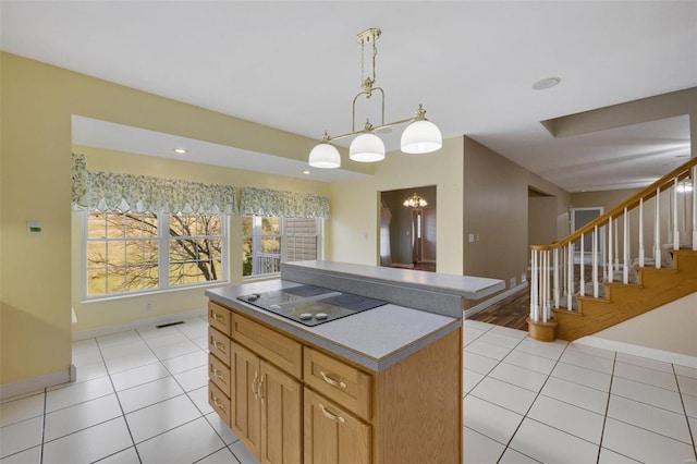 kitchen featuring black electric stovetop, light tile patterned floors, baseboards, and a kitchen island