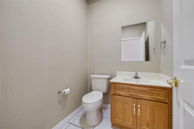 bathroom with tile patterned flooring, toilet, vanity, and baseboards