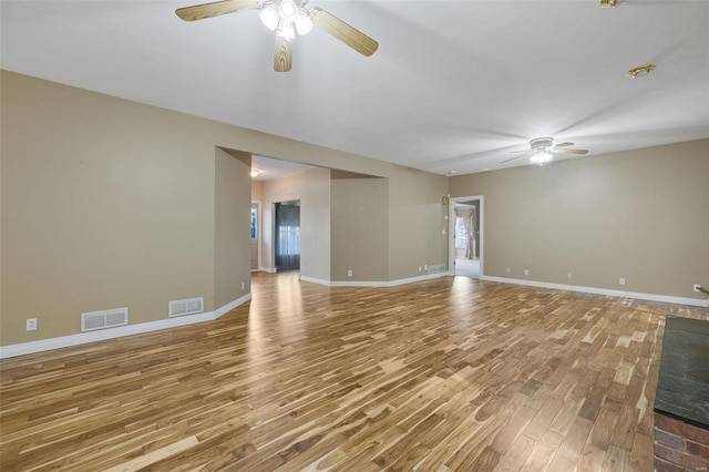 spare room with visible vents, ceiling fan, baseboards, and wood finished floors