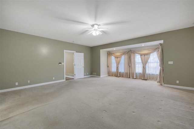 unfurnished room featuring light carpet, visible vents, ceiling fan, and baseboards