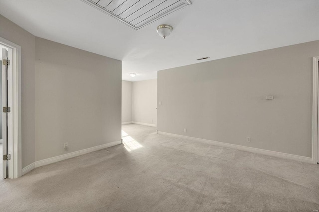 empty room featuring visible vents, light carpet, and baseboards