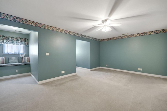 carpeted empty room featuring visible vents, baseboards, and ceiling fan