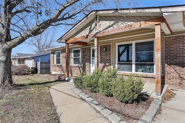 view of front of home featuring brick siding and a porch