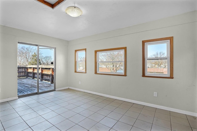 unfurnished room with light tile patterned flooring and baseboards