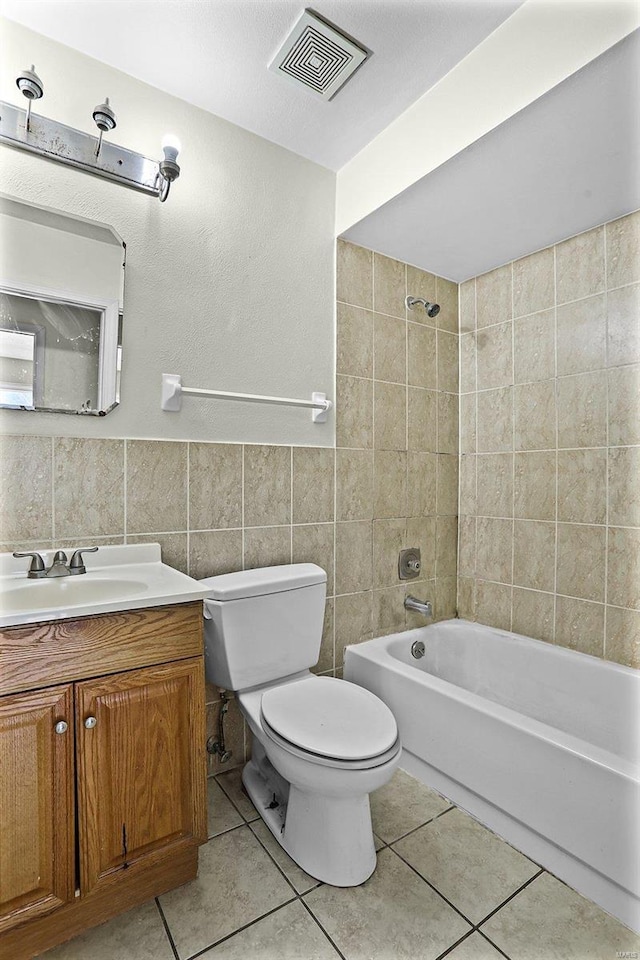 full bathroom featuring tile patterned floors, visible vents, toilet, tile walls, and shower / bathtub combination