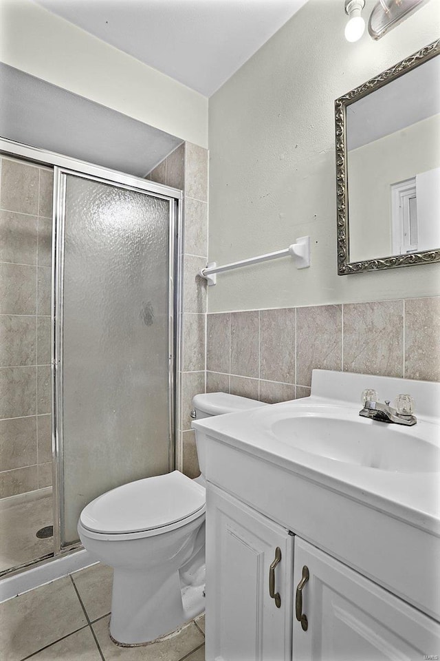 full bath with tile patterned floors, a shower stall, tile walls, and toilet