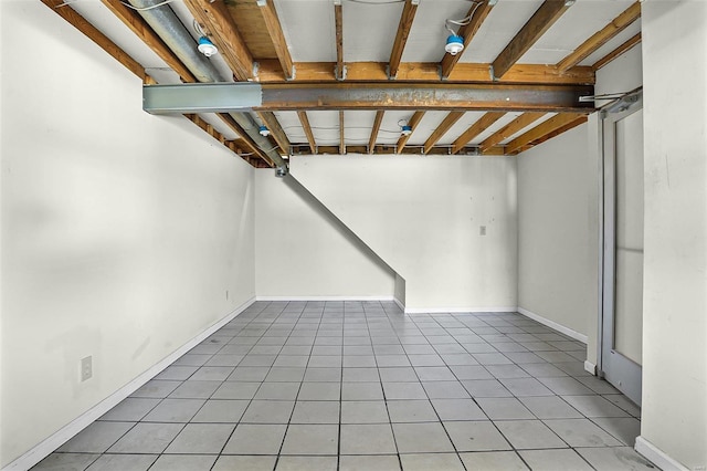 basement featuring tile patterned floors and baseboards