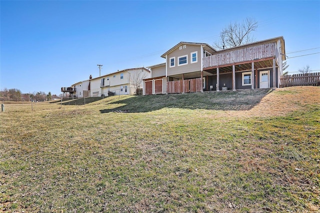 back of house featuring a lawn and fence