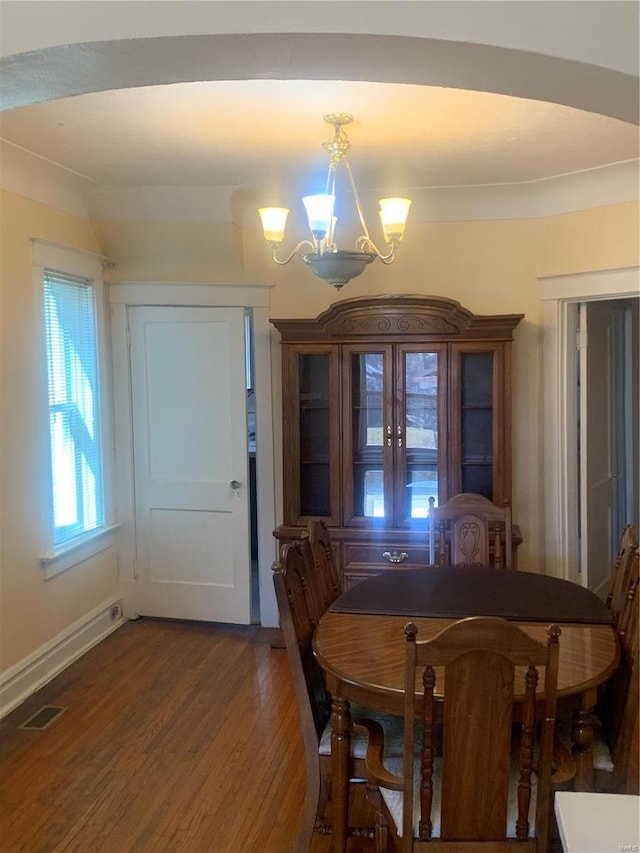 dining area with a notable chandelier, wood finished floors, visible vents, and baseboards