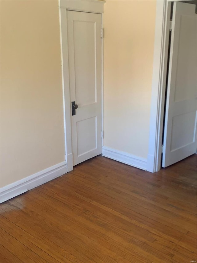 unfurnished room with baseboards and wood finished floors