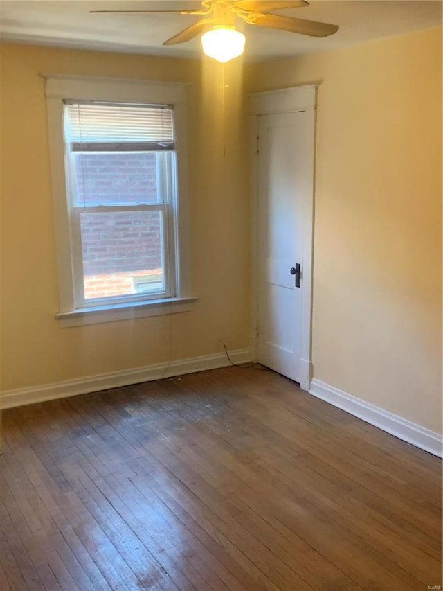 unfurnished room with a ceiling fan, baseboards, and hardwood / wood-style floors