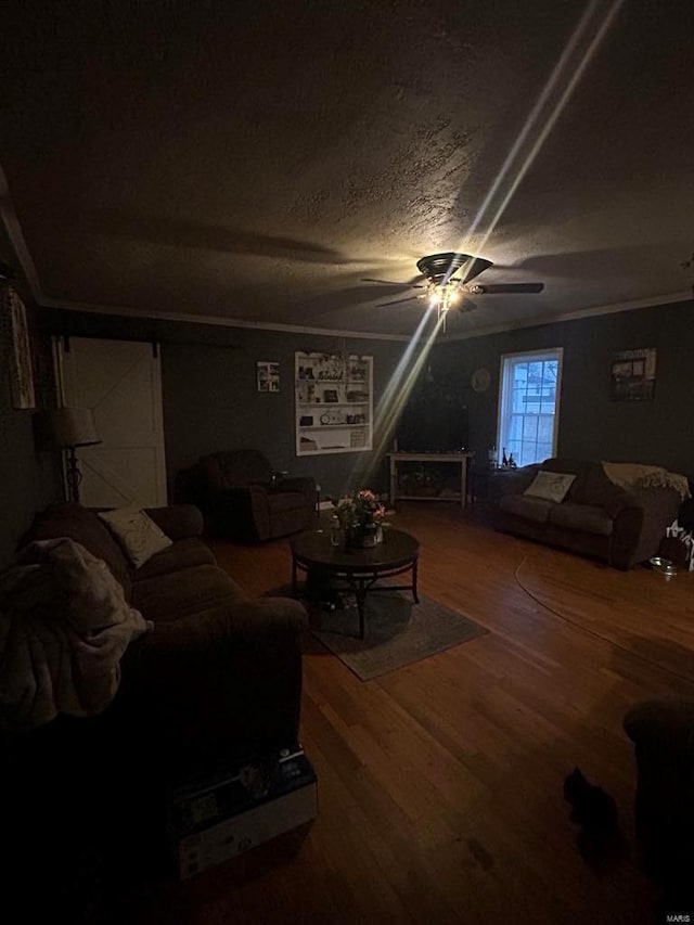 living room featuring a ceiling fan, crown molding, wood finished floors, and a textured ceiling