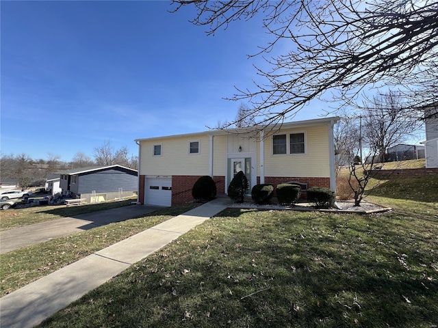 split foyer home featuring brick siding, a garage, driveway, and a front yard