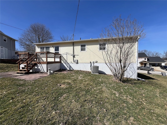 back of property featuring a deck, cooling unit, and a yard