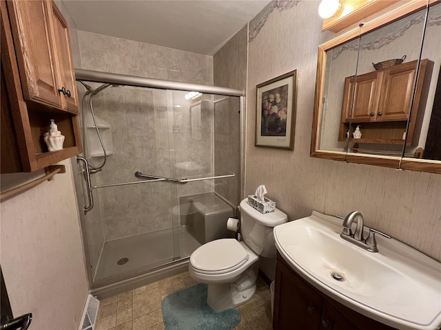 bathroom with visible vents, a shower stall, toilet, tile patterned floors, and vanity