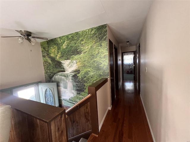 corridor with baseboards and wood finished floors