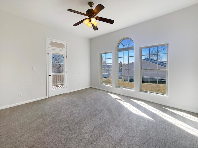 carpeted spare room with baseboards and ceiling fan